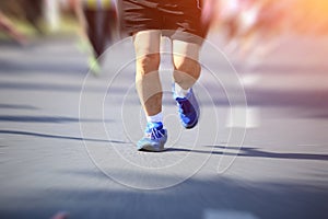 People feet on city road in marathon running race