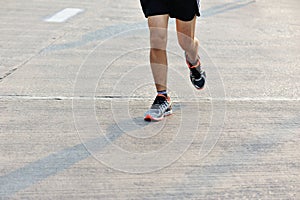 People feet on city road in marathon running race