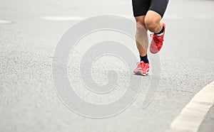 People feet on city road in marathon running race