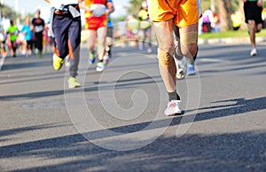 People feet on city road in marathon running race