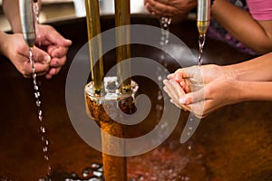 People filling up their hands with mineral water