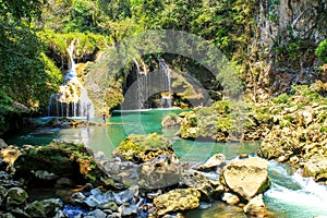People fishing in Semuc champey natural pool, waterfall and rocks from riverside