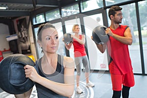 People in fitness class holding round prop