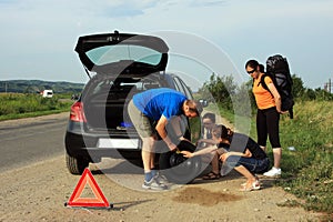 People fixing a flat tire