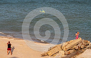 People fly a kite, by the sea