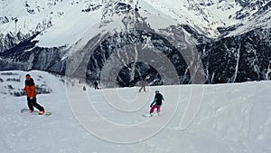 People are freeriding down the hill of a mountain, aerial shot in 4k