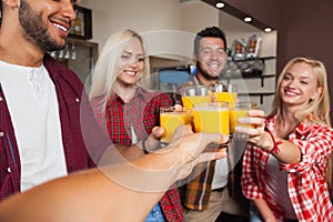 People Friends Drinking Orange Juice, Toasting At Bar Counter, Mix Race Man And Woman Cheers