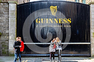 People in front of the historic old factory building wooden gate entrance at Guinness St. JamesÃÂ´s Gate Brewery in Dublin.