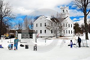 People gather on a frozen pond to ice skate and play hockey