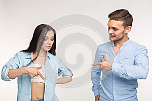 People and gesture concept - young pretty woman and handsome man pointing down over white background