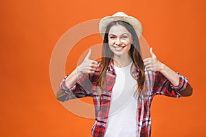 People, gesture, style and fashion concept - happy young woman or teen girl in casual clothes showing thumbs up, isolated over