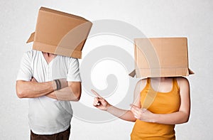 People gesturing with empty box on their head