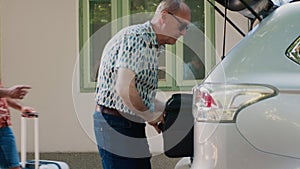 People getting ready for citybreak journey while putting baggage inside vehicle.