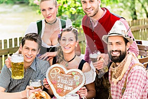 People with gingerbread heart in beer garden