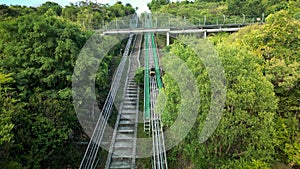 People go up the mountain on an green electric sled. Roller coaster, sled, POV of a rider on a sled roller coaster track