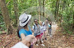 People Group With Backpacks Trekking On Forest Path Holding Hands Helping, Mix Race Young Men And Woman On Hike Tourists