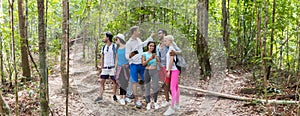 People Group With Backpacks Trekking On Forest Path Using Cell Smart Phone Map, Young Men And Woman On Hike