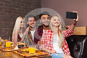 People Group Eating Fast Food Burgers Potato Sitting At Wooden Table In Cafe Taking Selfie Photo