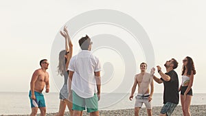 People group have fun and play beach volleyball at summer day