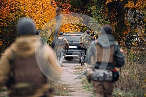 People with guns follow the car.Selective focus