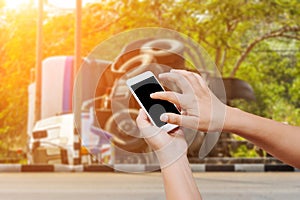 people hand hold and touch screen smart phone on overturned truck accident background