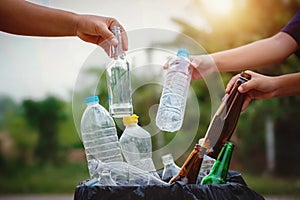 people hand holding garbage bottle plastic and glass putting into recycle bag for cleaning