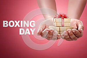 People hand holding gift box with Boxing day sign