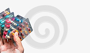 People hand holding pack of antibiotic capsule pills isolated on white background. Giving or receiving drug. Antibiotic drug.