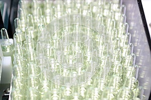 People hand holding a test tube vial sets for analysis in the gas liquid chromatograph. Laboratory assistant inserting laboratory