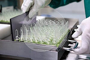 People hand holding a test tube vial sets for analysis in the gas liquid chromatograph. Laboratory assistant inserting laboratory