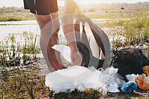 people hand picking up garbage plastic for cleaning at river park