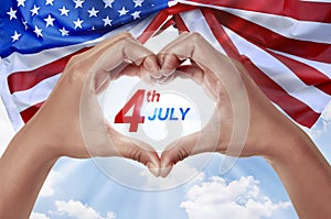 People hand in shape of heart with 4th of July message