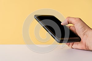 People hand using smartphone with blank yellow clear background. Business, financial, trade stock maket and social network
