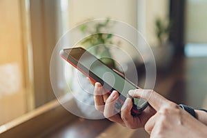 People hand using smartphone with blur cafe shop background