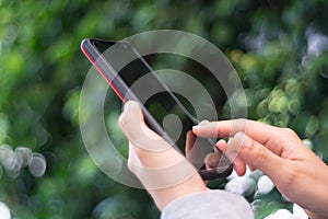 People hand using smartphone with blur cafe shop background