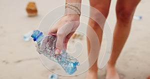 People, hands and beach with plastic bottle for recycling, cleaning or saving the planet in nature. Closeup of volunteer