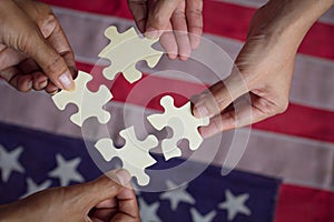 People Hands connections together, strategy team with jigsaw puzzle pieces over USA flag background