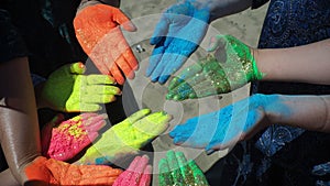 People hands covered in paint at Holi festival