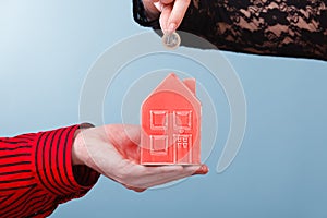 People hands with little house and silver coin.