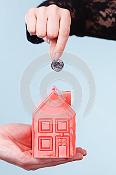 People hands with little house and silver coin.