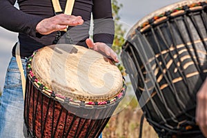 People hands playing music at djembe drums