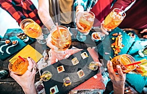 People hands toasting multicolored spritz drinks - Trendy friends having fun together drinking cocktails on happy hour at bar