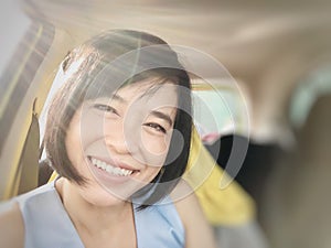 Selfies of girl smiling or Asian woman smiling in the car and looking at camera