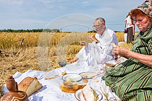 People have breakfast, traditional meal in open at the harvest time