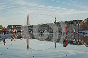 People have fun and refresh on a hot summer day, in the mirror fountain in front of the Place de la Bourse in Bordeaux