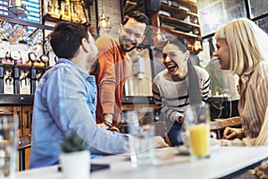 People have a great time in a cafe. Friends sitting in a coffee shop, drinking coffee, and having fun together