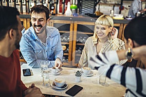 People have a great time in a cafe. Friends sitting in a coffee shop, drinking coffee, and having fun together