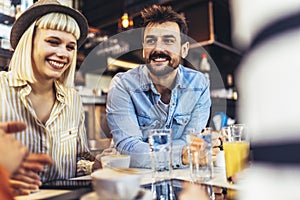 People have a great time in a cafe. Friends sitting in a coffee shop, drinking coffee, and having fun together