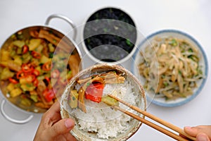 People have lunch in daily meal with Vietnamese vegan food, hand hold rice bowl and eating