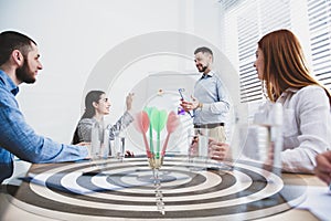 People having business meeting and dart board. Double exposure